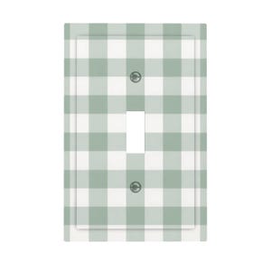 May include: A light green and white gingham pattern single-pole light switch cover. The cover has a rectangular shape with a single toggle switch opening and two screw holes. The design is a classic, farmhouse style.