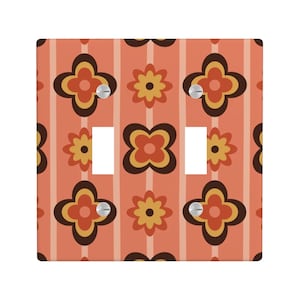 Puede incluir: Cubierta decorativa para interruptor de luz con un patrón floral retro. La cubierta presenta un diseño repetido de flores marrones, amarillas y naranjas sobre un fondo naranja a rayas. Incluye dos aberturas para interruptores y tornillos plateados.