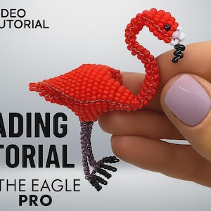 May include: A handcrafted, beaded flamingo in vibrant red, with a curved neck and detailed beak. The flamingo is held in a hand, showcasing the intricate beadwork. Text on the image reads "Beading Tutorial" and "Video Tutorial".