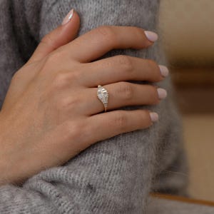 Minimalist engagement ring featuring baguette cut diamonds and slim gold band