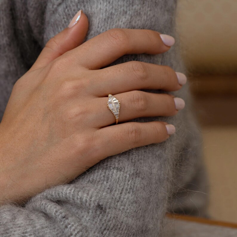 Minimalist engagement ring featuring baguette cut diamonds and slim gold band