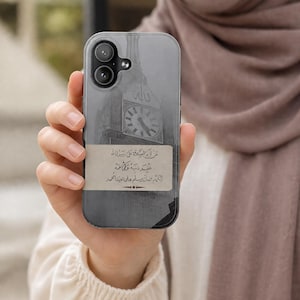 Peut inclure: Coque de smartphone avec une image en niveaux de gris d'une tour d'horloge et des inscriptions arabes. La coque est tenue à la main, mettant en valeur le design et l'appareil photo du téléphone.