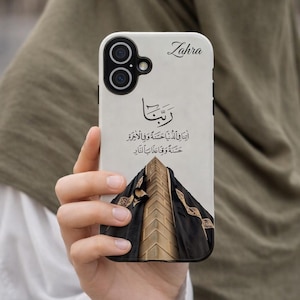 Könnte beinhalten: Weißes Handycase mit einem schwarz-goldenen Design mit arabischer Kalligraphie und einer Gebäudeillustration. Auf dem Case ist der Name "Zahra" aufgedruckt.