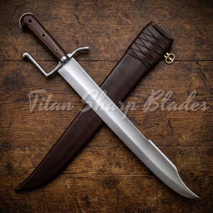 Op de afbeelding: Een groot, gepolijst stalen mes met een donkerhouten handvat en een bruine leren schede. Het mes kruist de schede op een houten oppervlak. De tekst "Titan Sharp Blades" is zichtbaar.