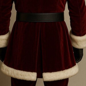 May include: A burgundy velvet Santa Claus suit with white faux fur trim on the cuffs and hem. The suit features a wide black belt and black gloves. A festive costume for Christmas celebrations.
