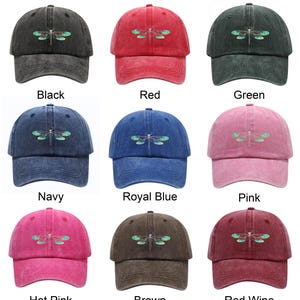 May include: A collection of baseball caps in various colors, including black, red, green, navy, royal blue, pink, hot pink, brown, and red wine. Each cap features a dragonfly design embroidered on the front.