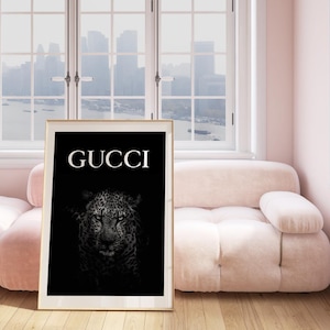 May include: Black and white poster featuring a close-up of a leopard's face with the word "GUCCI" in white text.