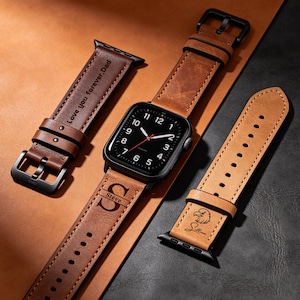 Può includere: Un cinturino per Apple Watch in pelle marrone con quadrante nero e due cinturini aggiuntivi. Un cinturino è inciso con "Love you forever, Dad", un altro con il nome "Steve" e l'iniziale "S", e il terzo con il nome "Sullivan" e un'aquila.