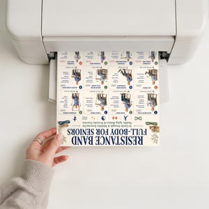 May include: A printed exercise chart titled RESISTANCE BAND FULL-BODY FOR SENIORS emerging from a white printer. The document features sixteen numbered illustrations of seated and standing exercises with text instructions and small icons.