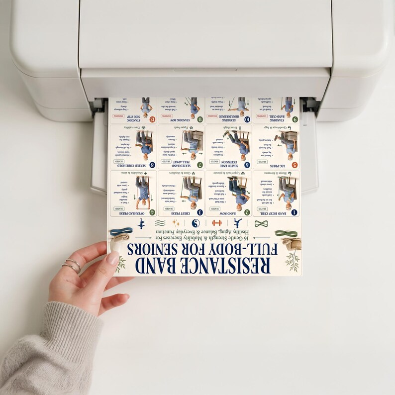 May include: A printed exercise chart titled RESISTANCE BAND FULL-BODY FOR SENIORS emerging from a white printer. The document features sixteen numbered illustrations of seated and standing exercises with text instructions and small icons.