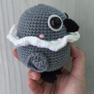 side view of sylus grumpy crow crochet doll from love and deepspace, showing wing detail, a blush, and rounded body shape.