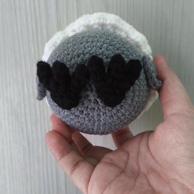 bottom view of sylus grumpy crow amigurumi, showing black three-toed feet.