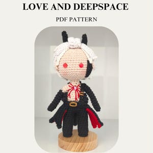 May include: A crocheted Sylus doll from the game Love and Deepspace, with white hair, red eyes, and a black outfit with red accents. The doll is displayed on a wooden base. Text on the image reads "SYLUS (ABYSM SOVEREIGN) LOVE AND DEEPSPACE PDF PATTERN."