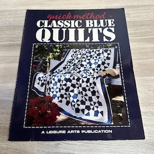 May include: A book titled "Quick-Method Classic Blue Quilts" with a blue and white quilt on the cover. The book is a Leisure Arts Publication.