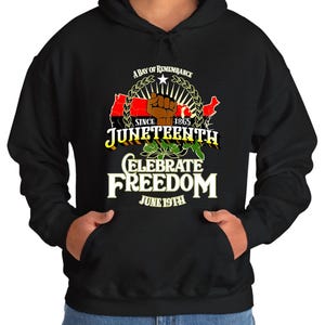 May include: Black hooded sweatshirt with a graphic design featuring a stylized map of the United States with a raised fist and the text "A Day of Remembrance Since 1865 Juneteenth Celebrate Freedom June 19th"