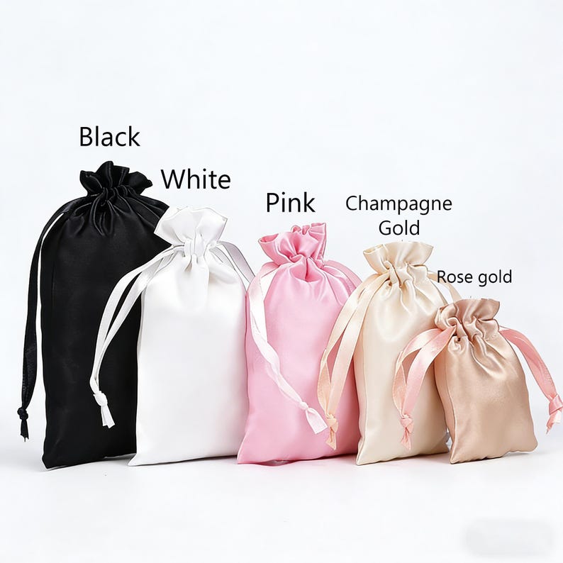 May include: Five satin drawstring bags in black, white, pink, champagne gold, and rose gold. Each bag has a matching satin drawstring closure. The text labels each bag's colour.