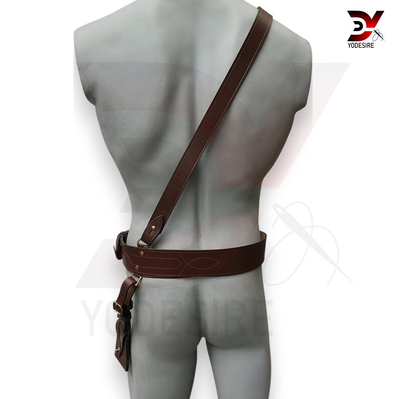 Pu&ograve; includere: Cintura in pelle marrone con un design decorativo e una tracolla abbinata. La cintura ha una fibbia e una piccola tasca.