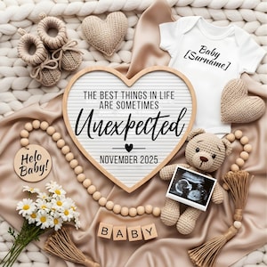 Op de afbeelding: Een aankondiging van een baby met een hartvormig bord met de tekst "THE BEST THINGS IN LIFE ARE SOMETIMES UNEXPECTED NOVEMBER 2025". Inclusief een babyromper, echo, gebreide teddybeer en houten blokken met de tekst "BABY".