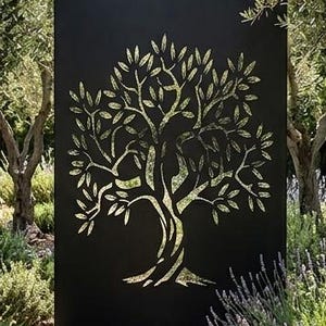 Peut inclure: Un panneau de séparation rectangulaire en métal noir présentant une découpe laser en forme d'olivier. La découpe laisse passer la lumière, projetant une ombre détaillée du motif de l'arbre sur le sol juste devant le panneau métallique.