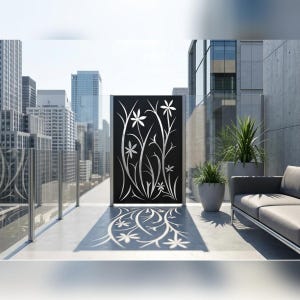 May include: A rectangular black metal privacy screen featuring a laser-cut floral pattern of stylized flowers and long, curved stems. The screen is positioned upright, casting a distinct shadow of the floral design onto the light-colored floor.