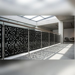 Peut inclure: Un panneau de garde-corps en métal noir présentant un motif répétitif de découpes carrées de tailles variées. Le panneau est fixé avec des poteaux en acier inoxydable et une main courante en bois, projetant des ombres géométriques au sol.