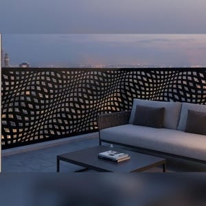Peut inclure: Un écran de confidentialité pour balcon en métal noir présentant un motif géométrique répétitif de carrés déformés créant un effet visuel ondulé. L'écran est installé comme garde-corps sur un balcon avec un canapé et une table basse au premier plan.