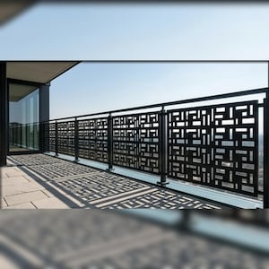 Può includere: Una ringhiera per balcone in metallo nero con pannelli rettangolari caratterizzati da un motivo geometrico traforato. La ringhiera è composta da montanti verticali e barre orizzontali, creando un design a griglia che proietta ombre sul pavimento.