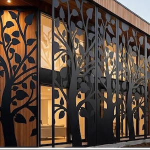 May include: Exterior view of a modern building with a decorative metal screen featuring a tree design. The screen is black, and the building has wooden siding. Large windows are visible behind the screen, and the overall aesthetic is contemporary.