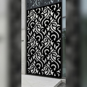 May include: A tall, rectangular metal privacy screen featuring a repeating black and white laser-cut pattern of swirling, organic scrollwork. The panel is mounted vertically against a building exterior, showcasing a high-contrast design.