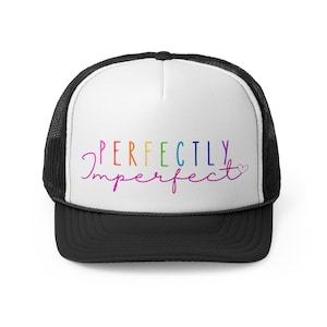 Peut inclure: Un chapeau de camionneur noir et blanc avec un panneau avant blanc comportant le texte "PERFECTLY Imperfect" en couleurs arc-en-ciel avec un petit cœur rose à la fin.