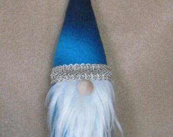 May include: A blue and white felt gnome ornament with a white beard and a silver trim around the hat.