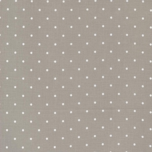 May include: A close-up of a light brown fabric with a white polka dot pattern.