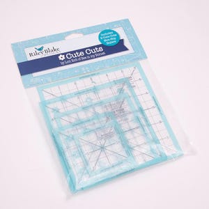 May include: A package of quilting rulers with the text "Cute Cuts" by Riley Blake Designs. The package includes five clear, square rulers with grid lines and measurements in inches. The rulers are in a clear plastic bag.