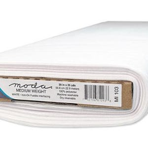 May include: A roll of white, medium-weight, non-woven fabric. The label reads "moda" and indicates the fabric is 20 inches wide and 25 yards long. The fabric is 100% polyester and is machine washable.