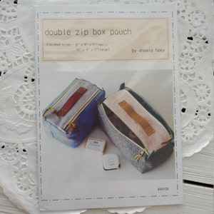 May include: A sewing pattern for a double zip box pouch. The pattern includes instructions for making two sizes: 8 inches by 4 inches by 5 inches (small) and 10 inches by 4 inches by 5 inches (large). The pattern is by Aneela Hoey and is labeled #AH108.