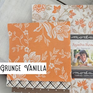 May include: A stack of fabric squares featuring an orange square with a white floral pattern, a white square with an orange floral pattern, a white square with a black grid, and a brown square with white dots, labeled Grunge Vanilla.