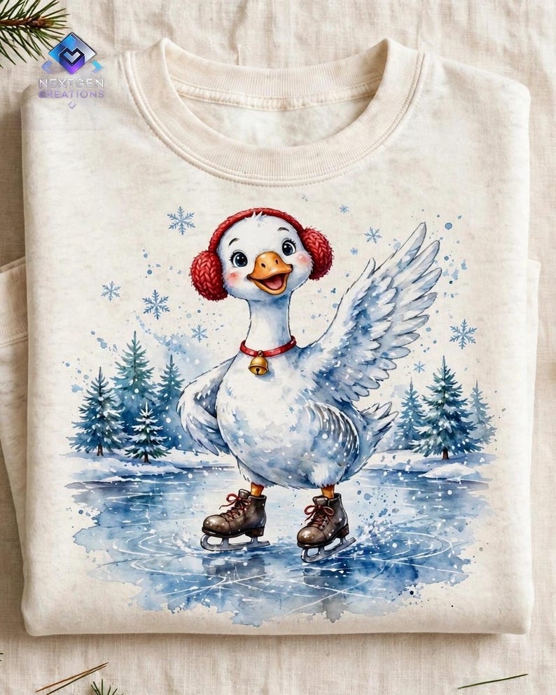 Puede incluir: Una sudadera de color crema con una ilustraci&oacute;n en acuarela de un ganso blanco que lleva orejeras rojas y un collar rojo con un cascabel dorado. El ganso patina sobre un estanque helado rodeado de pinos y copos de nieve que caen.