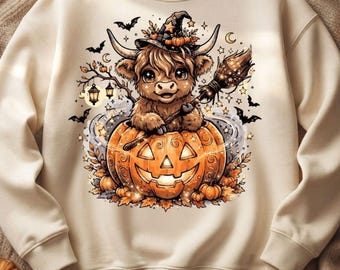 Puede incluir: Una sudadera de cuello redondo color crema con un gráfico de una vaca highland peluda con sombrero de bruja, sosteniendo una escoba y sentada dentro de una gran calabaza tallada rodeada de murciélagos, estrellas y linternas.