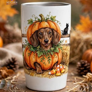 May include: A white cylindrical tumbler featuring a graphic illustration of a brown dachshund dog sitting inside a carved orange pumpkin. The design includes green ivy leaves, a small black cat on a wooden fence, and scattered candy corn.