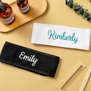 May include: A white ceramic mug with a black handle and the text "But First, Coffee" in a black, handwritten-style font. The mug is on a white surface.