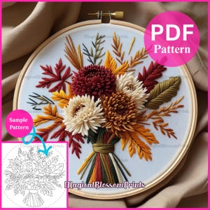 Könnte beinhalten: Ein Stickrahmen mit einem detaillierten Blumendesign in herbstlichen Farben. Das Design umfasst bordeauxrote, cremefarbene, gelbe und grüne Blumen und Blätter. Der Text "PDF Pattern" und "Sample Pattern" sind sichtbar.