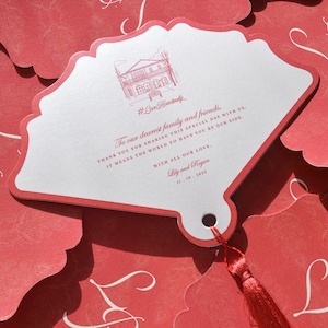 May include: Red and white wedding invitation with a tassel. The invitation features a house illustration and text that reads "To our dearest family and friends." The date 11.10.2013 is also visible.
