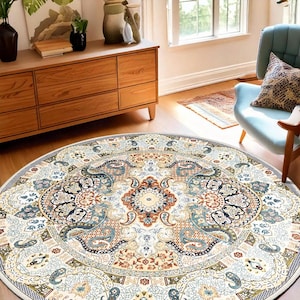 Puede incluir: Una alfombra redonda con un dise&ntilde;o intrincado y ornamentado. La alfombra presenta un medall&oacute;n central en tonos beige, azul y &oacute;xido, rodeado por un borde detallado. El patr&oacute;n general recuerda a las alfombras persas tradicionales.