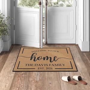 May include: A brown doormat with the text "Welcome to our home The Davis Family Est. 2024" in a black frame.