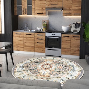 Puede incluir: Una cocina con armarios de madera, un fregadero de acero inoxidable y un horno negro. En el suelo hay una alfombra redonda con un estampado floral en tonos azules, naranjas y crema. Un sof&aacute; gris est&aacute; en primer plano. El di&aacute;metro de la alfombra es de unos 200 cm.