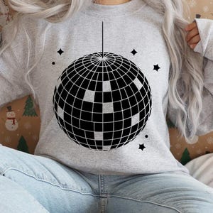 May include: A gray sweatshirt with a black and white disco ball graphic on the front.