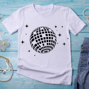 May include: White t-shirt with a black disco ball graphic and small stars printed on the front.