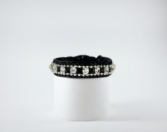 May include: A black choker necklace with a row of clear rhinestones.