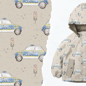 Könnte beinhalten: Eine beige Stoffjacke mit einem Muster aus blauen und weißen Polizeiautos. Die Jacke hat eine Kapuze und einen Reißverschluss. Die Polizeiautos haben den Schriftzug "Polizei" aufgedruckt.