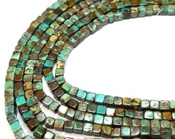 May include: Strands of square turquoise beads in varying shades of blue-green and brown. The beads are strung together, creating a textured and colorful display. Ideal for jewelry making or crafting projects.
